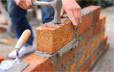 builder laying down bricks