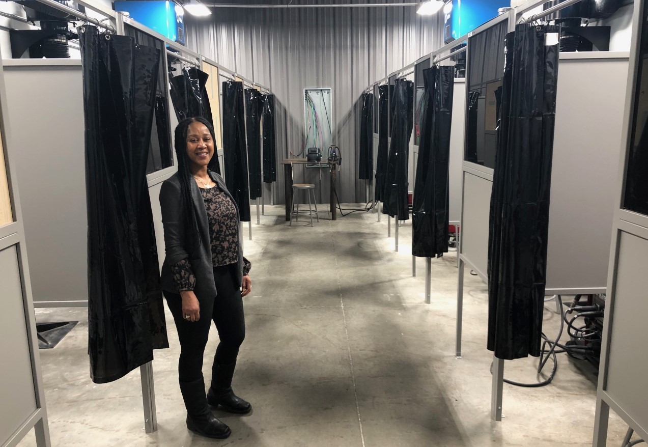 Patrecia Gary, the trades center coordinator at the new Toano facility, stands among the 10 welding bays.