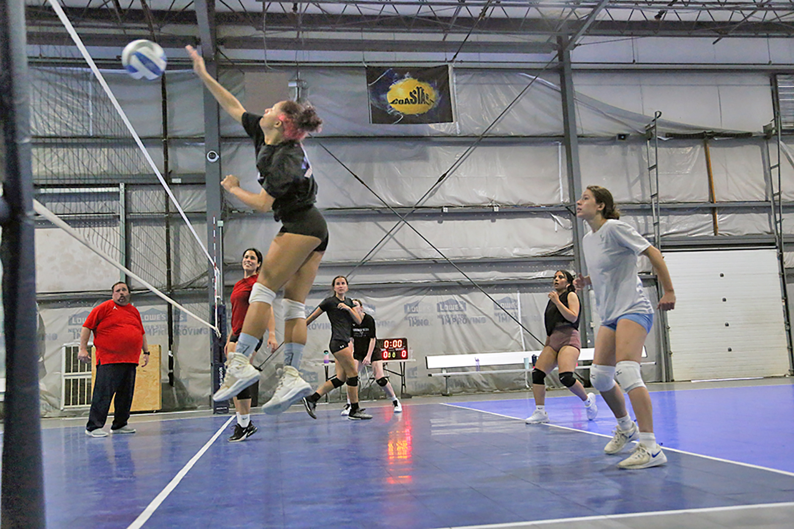 Coach Tommy Thomas and the women's volleyball team during practice