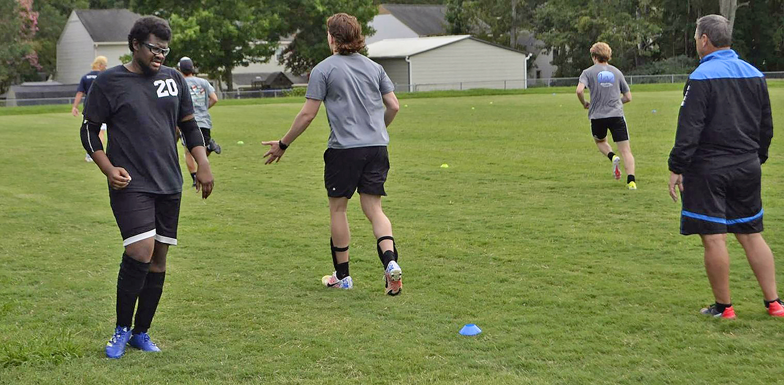 Keith Utsey (left), VPCC Men's Soccer coach Kevin Darcy (right), and the Men's Soccer team during practice