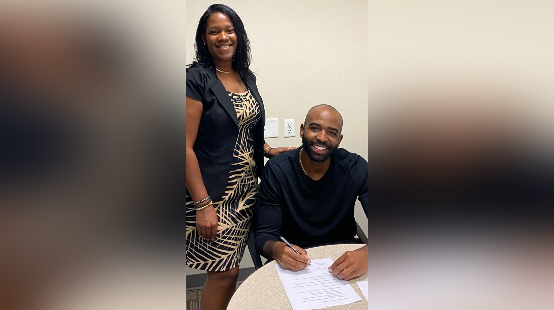 Shante Bell (left), the College's alumni and annual giving coordinator, and Ryaan Boyd sign the documents for establishing a scholarship