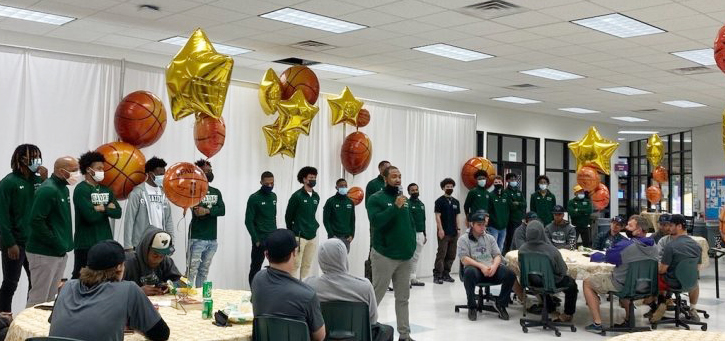 Coach Chris Moore (speaking) and the men's basketball team at the annual sports awards gathering