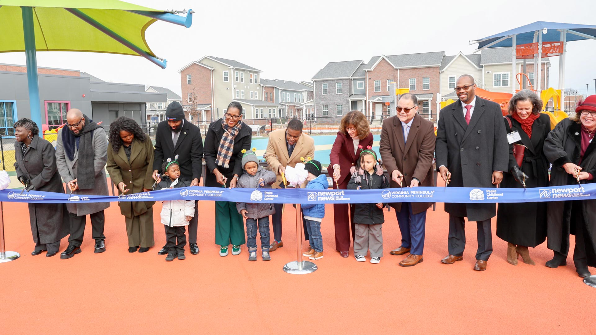 VPCC President Dr. Towuanna Porter Brannon (in scarf) joined Newport News dignitaries, officials from the Peake Childhood Center and children in cutting the ribbon for the Newport News Early Childhood Development Center.